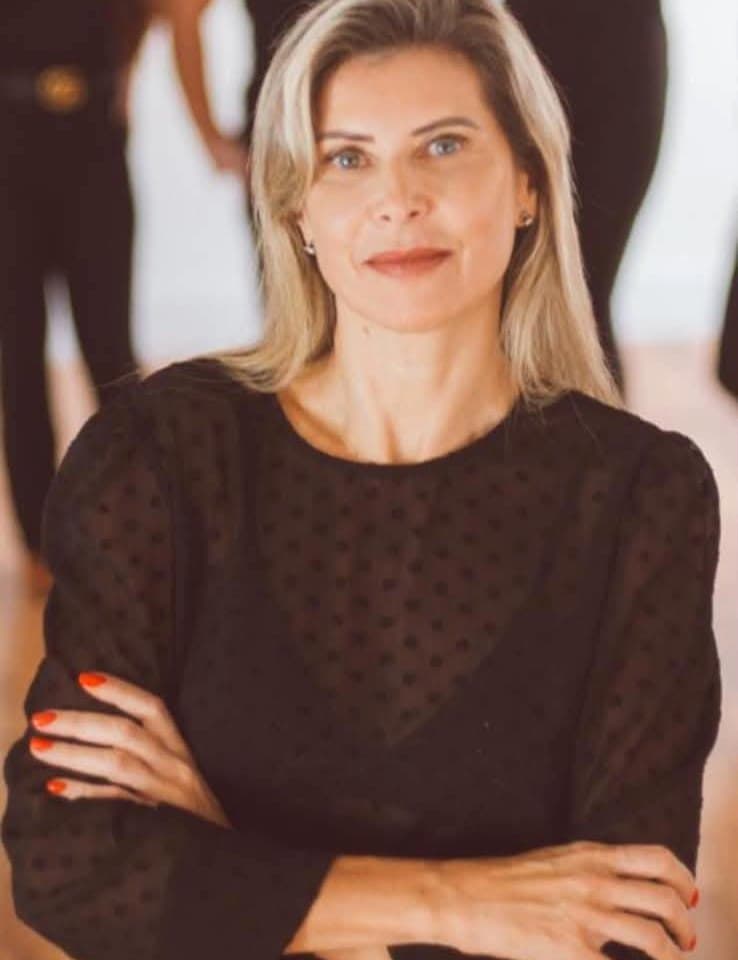 Dra. Christianne Feldmann, especialista em estética facial regenerativa, em retrato profissional de braços cruzados